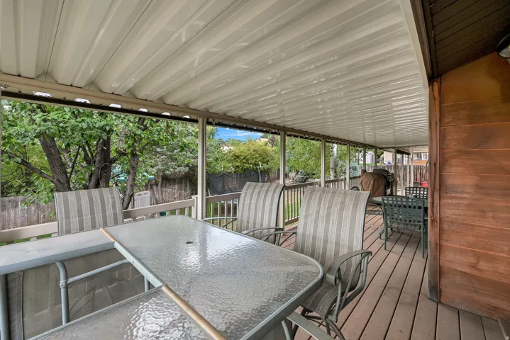 Expansive covered deck featuring wood-finish flooring, a metal awning, and wood railings