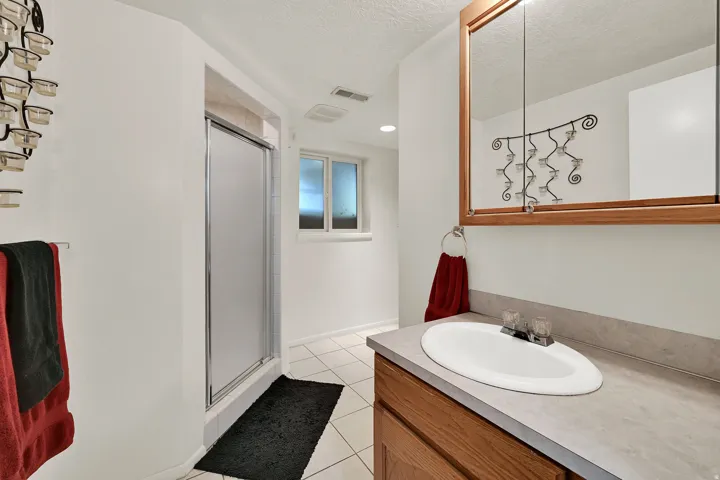 Bathroom with a built-in wood vanity, integrated sink, and an overhead mirrored medicine cabinet