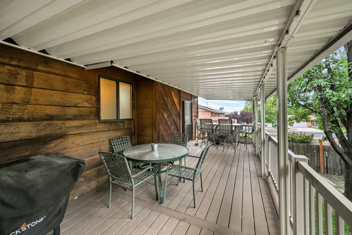 Expansive covered deck featuring wood-finish flooring, a full-length overhead cover, and durable railing
