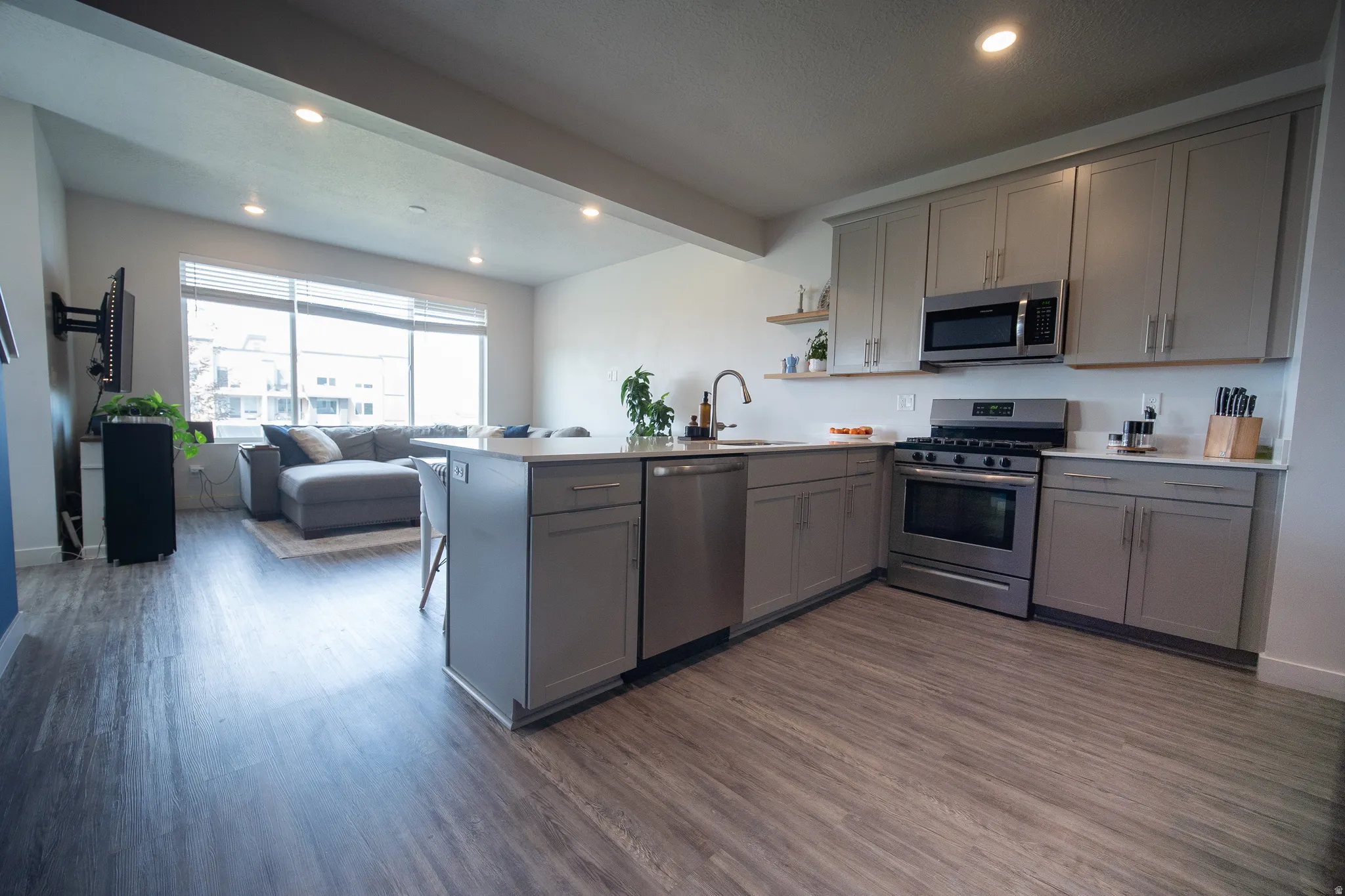 Stylish kitchen showcasing wood-look flooring, recessed lighting, ample cabinet storage, modern finishes, and a functional layout designed for convenience.