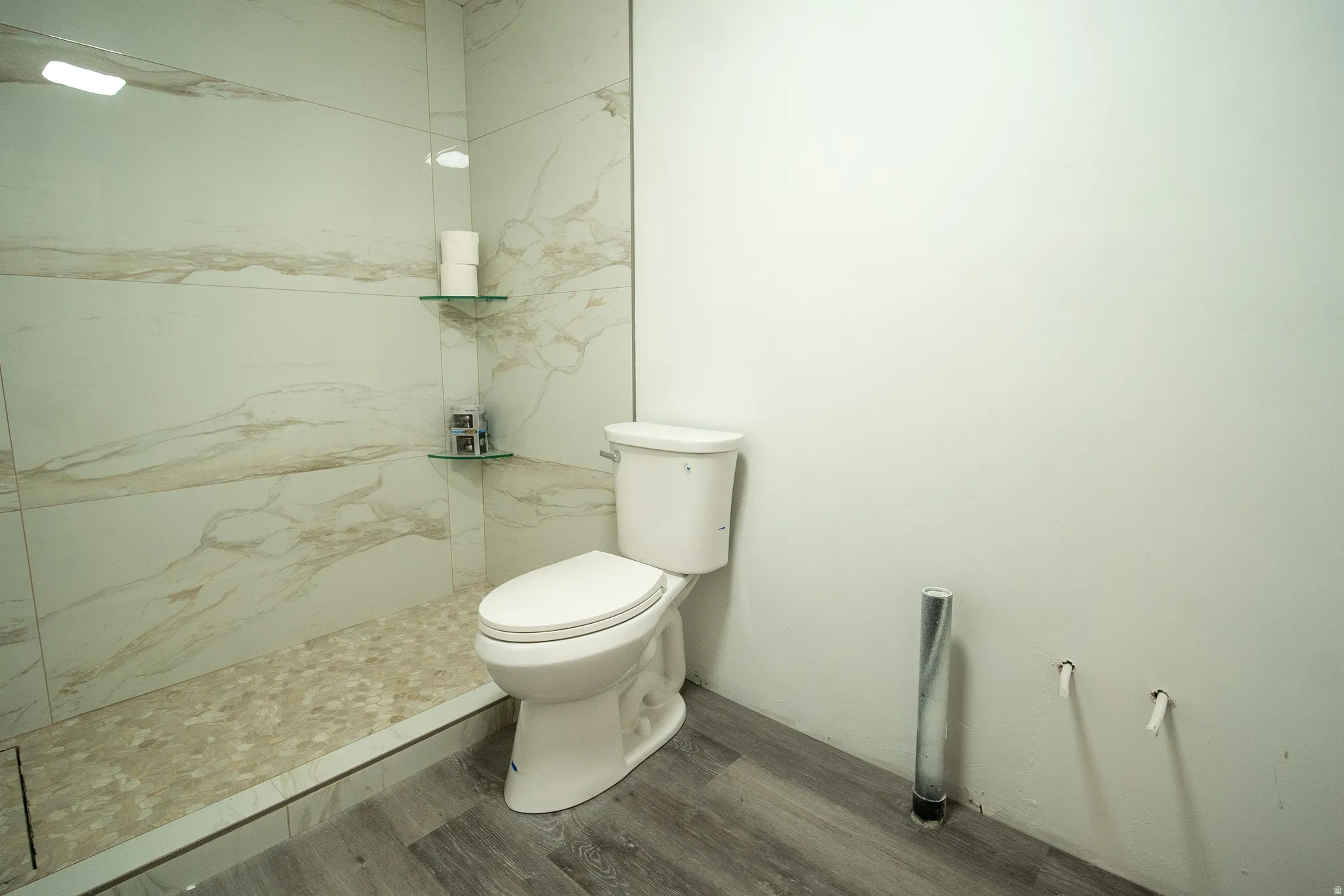 The basement bathroom is already well underway, featuring a beautifully tiled walk-in shower with glass shelving, a pebble floor, and modern finishes. Just a few final touches remain to complete the space and add instant value.