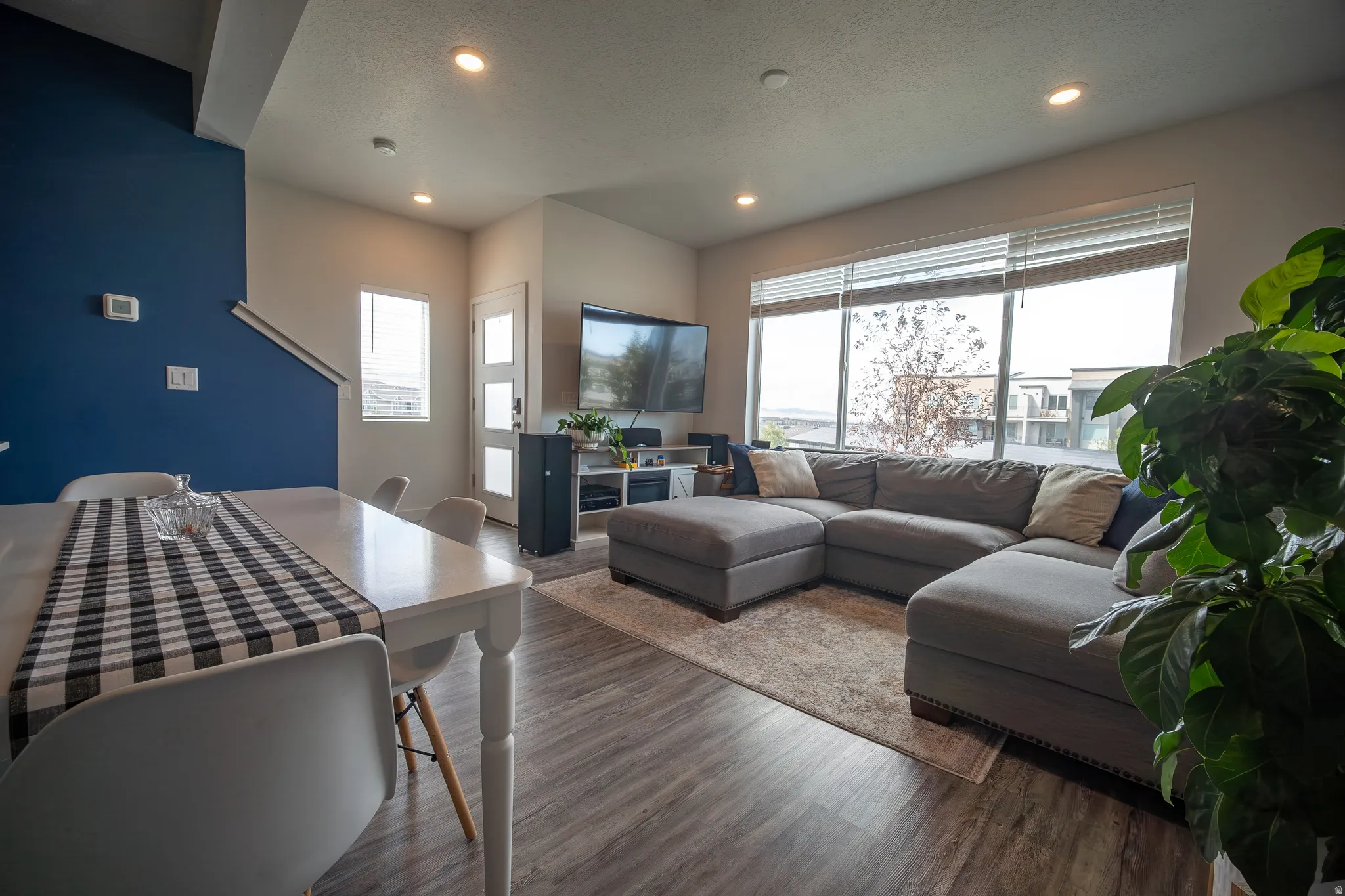 Bright and inviting living room featuring recessed lighting, large windows that provide abundant natural light, and an open layout ideal for relaxing and entertaining.
