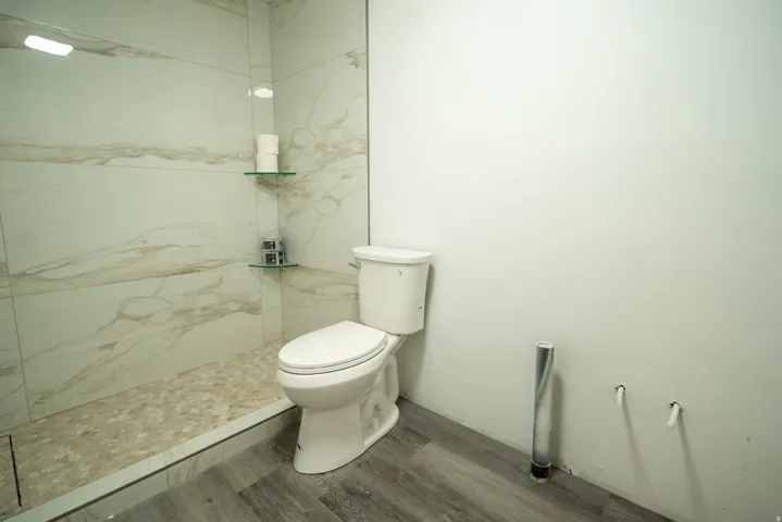 The basement bathroom is already well underway, featuring a beautifully tiled walk-in shower with glass shelving, a pebble floor, and modern finishes. Just a few final touches remain to complete the space and add instant value.