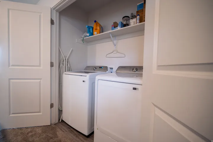 Convenient upstairs laundry room featuring a washer and dryer, built-in shelving for storage, and easy access to all bedrooms for added functionality.