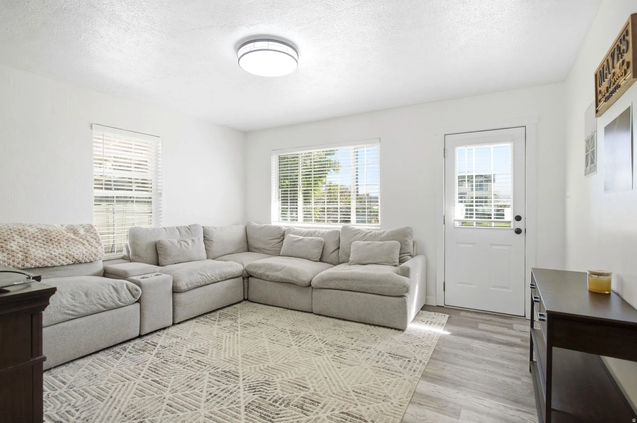 Recessed lighting, multiple windows with blinds, and a glass-paneled exterior door