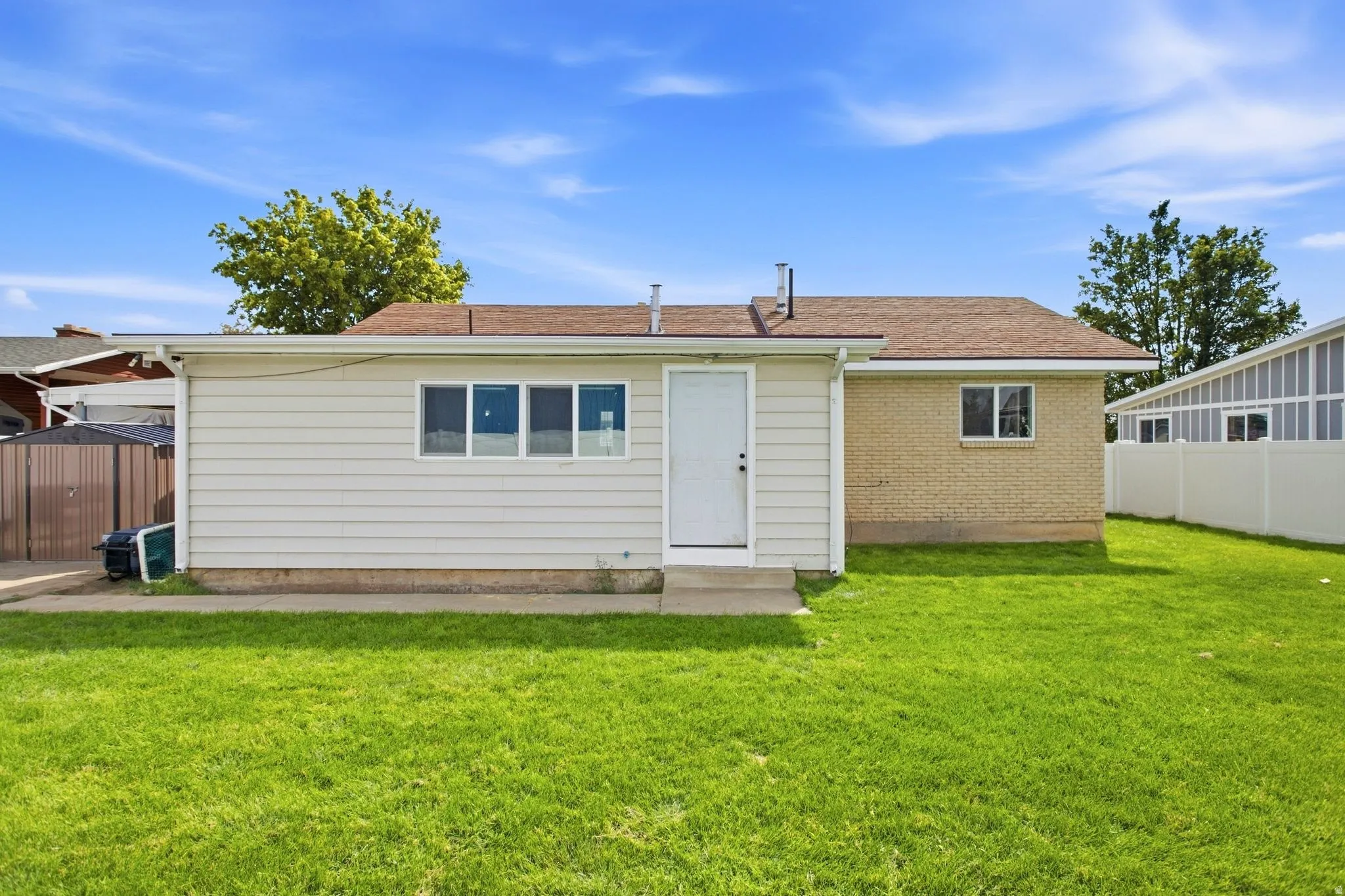 Spacious grassy yard with an extended patio area