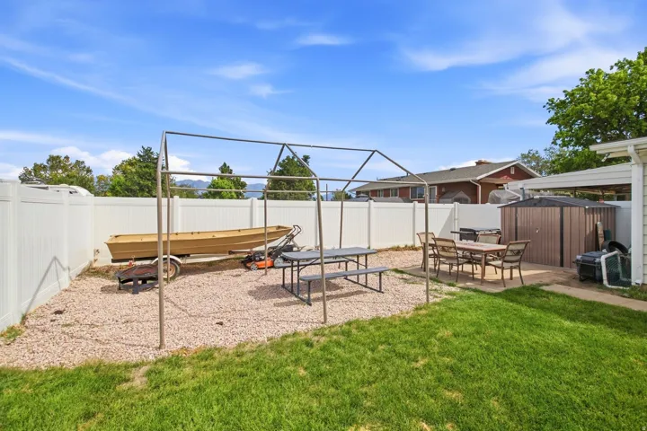 Expansive backyard featuring a manicured lawn, a gravel area, and a paved patio space