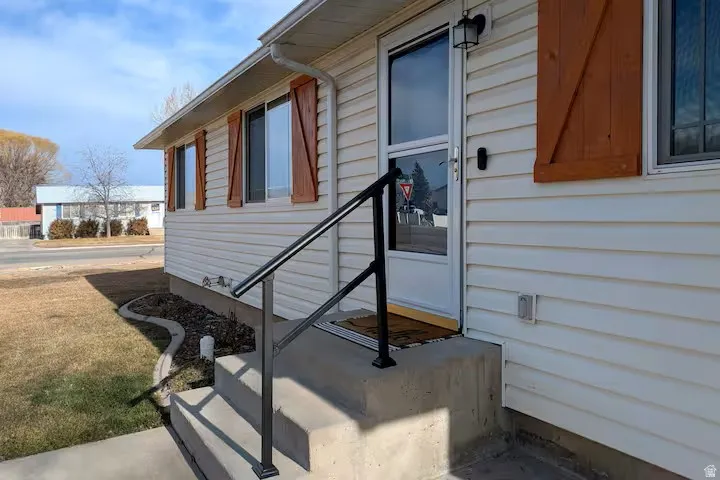 White siding exterior with wood-finish decorative shutters