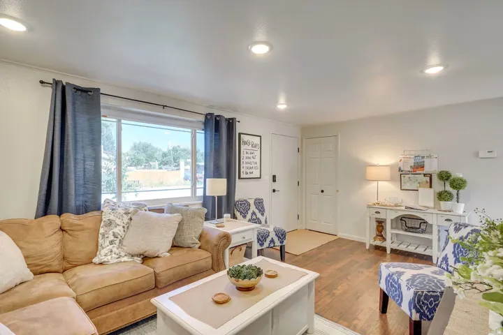 Recessed lighting, wood-finish flooring, white trim, and a large window