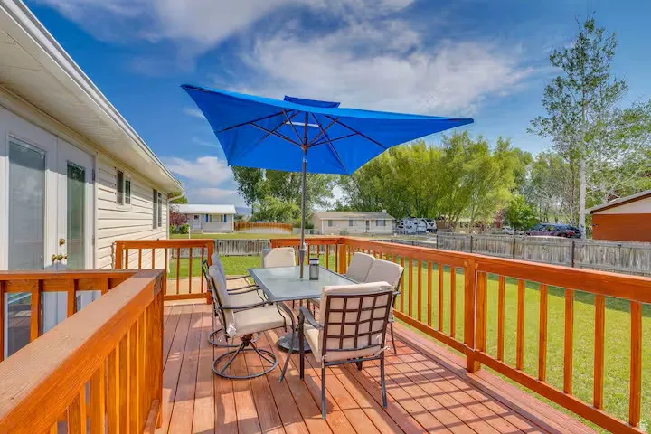 Spacious outdoor deck with wood railing, offering exterior access and a wide-open outdoor area