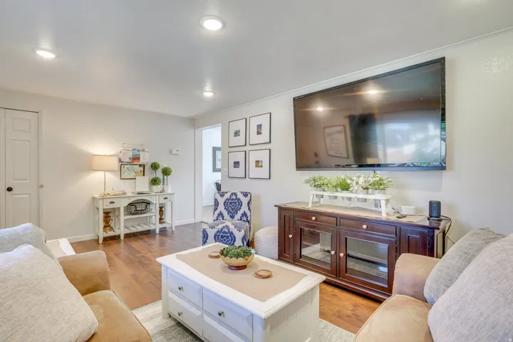 Recessed lighting, wood-finish flooring, white paneled doors, and a built-in media console