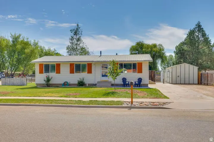 Single-story residence featuring light-colored siding, a metal roof, and orange shutters