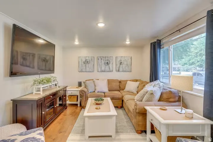Recessed lighting, wood-finish flooring, a large window, and a built-in media console