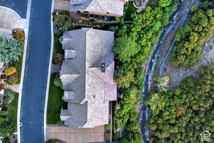 Gabled roofline residence with multiple dormers, chimney, and an attached driveway