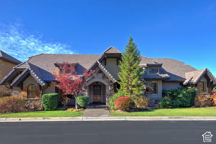 Stone and stucco exterior with multiple gables and a tiled roof