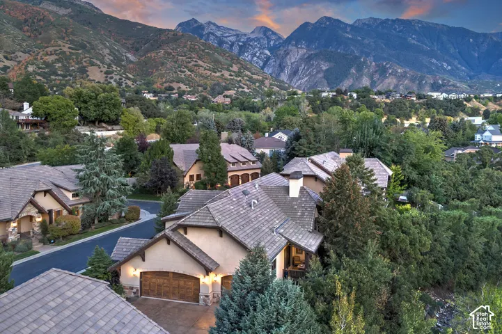 Mountain backdrop with residential properties featuring tiled roofs, stucco exteriors, and attached garages
