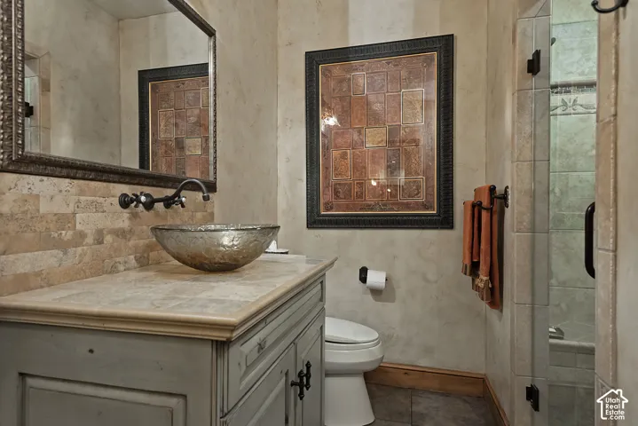 Custom vanity with a vessel sink, stone countertop, and an ornate framed mirror