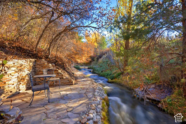 Flagstone patio with a stone retaining wall, adjacent to a natural stream