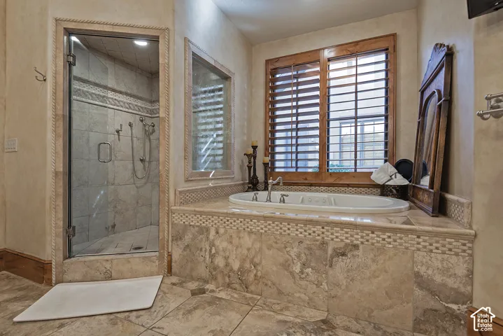 Walk-in shower with clear glass enclosure and tile surround