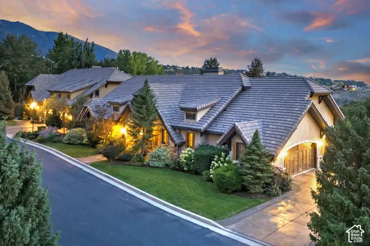 Stone and stucco exterior with multiple gables and a tile roof