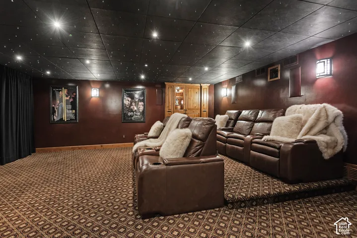 Patterned carpeted flooring, built-in wall sconce lighting, dark accent wall, recessed lighting, wood-finish built-in cabinetry