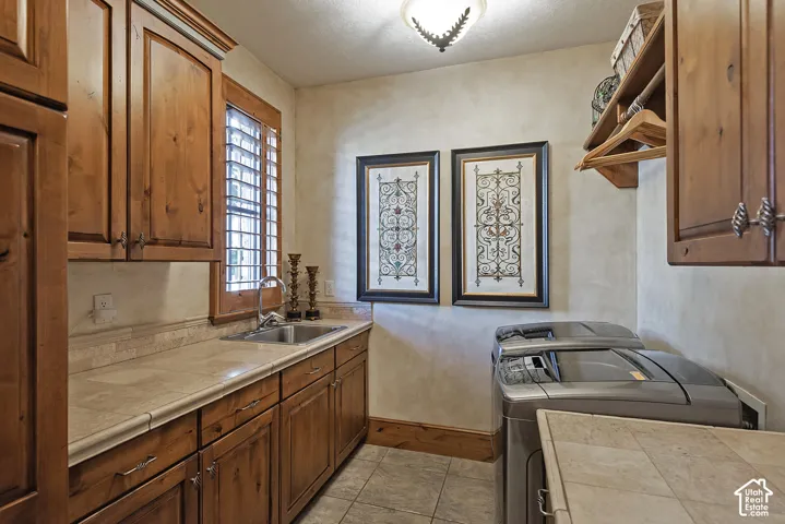Utility area featuring wood cabinetry, integrated sink, and an extensive countertop