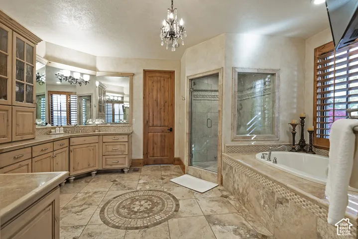 Dual vanity with light wood-finish cabinetry, a separate shower enclosure, and a built-in soaking tub