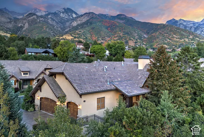 Stucco exterior with stone accents and a multi-level tile roof