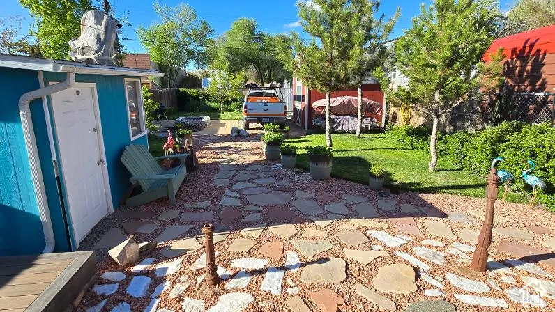 Expansive backyard featuring a flagstone and gravel patio, a manicured lawn, and mature trees
