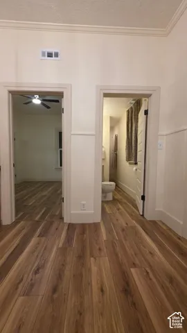 Wood-finish flooring throughout, crown molding, and wainscoting