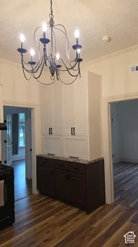 Custom built-in cabinetry featuring a two-tone finish, stone-pattern countertop, dark lower cabinets, and light upper storage