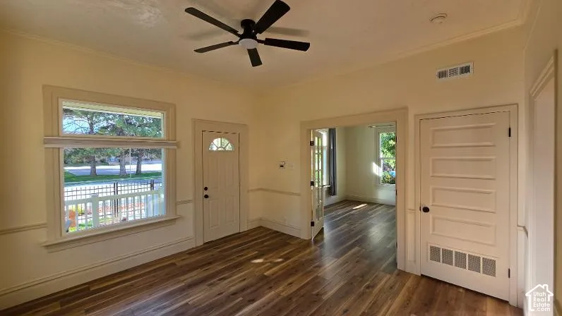 Wood-finish flooring, ceiling fan, white paneled interior doors, and a glass-paneled exterior door