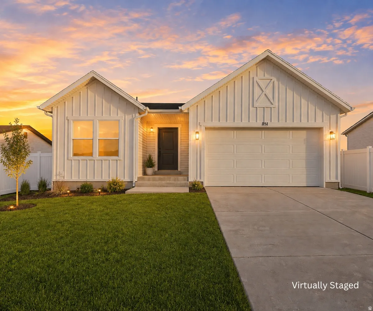 Board and batten exterior with an attached garage, concrete driveway, and front landscaping