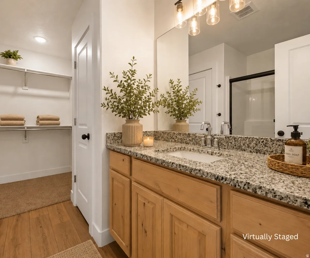 Granite-style countertop, wood-finish vanity, undermount sink, and wood-finish flooring