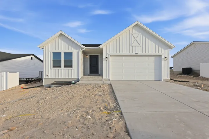 White board and batten exterior with contrasting dark entry door, attached garage with carriage-style lighting, and concrete driveway