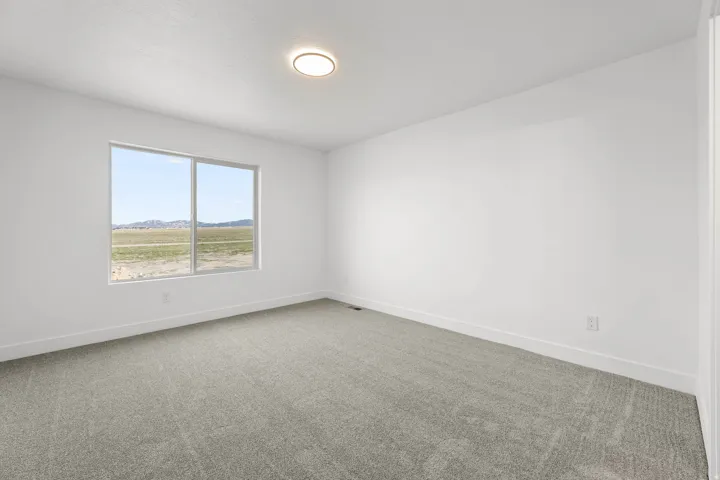 Recessed lighting, light-toned carpeting, and a large window providing expansive scenery