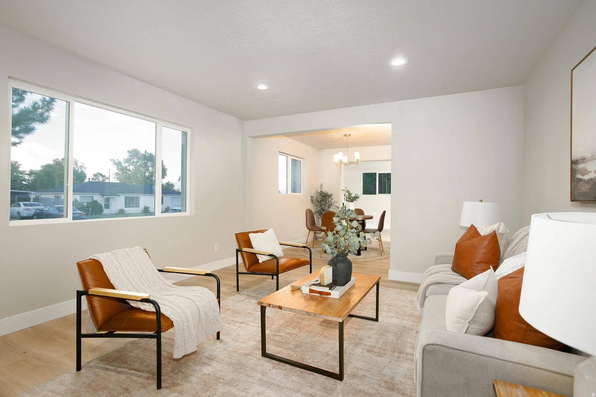 Recessed lighting, light wood-finish flooring, broad window, and neutral wall tones
