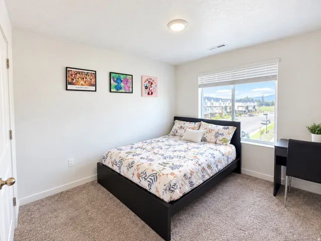 Neutral wall paint, carpeting, and a large window with blinds