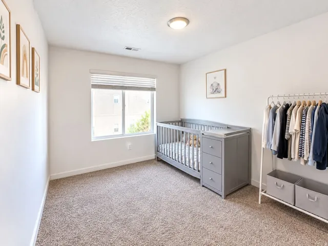 Light-colored carpeting, white walls, recessed window with blinds, and flush-mount ceiling lighting