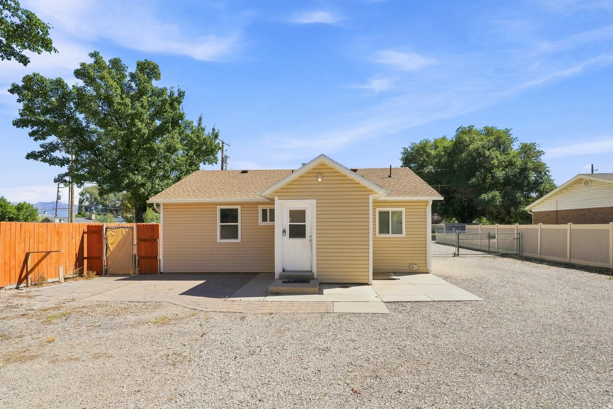 Single-story exterior with light beige siding and a front entry door