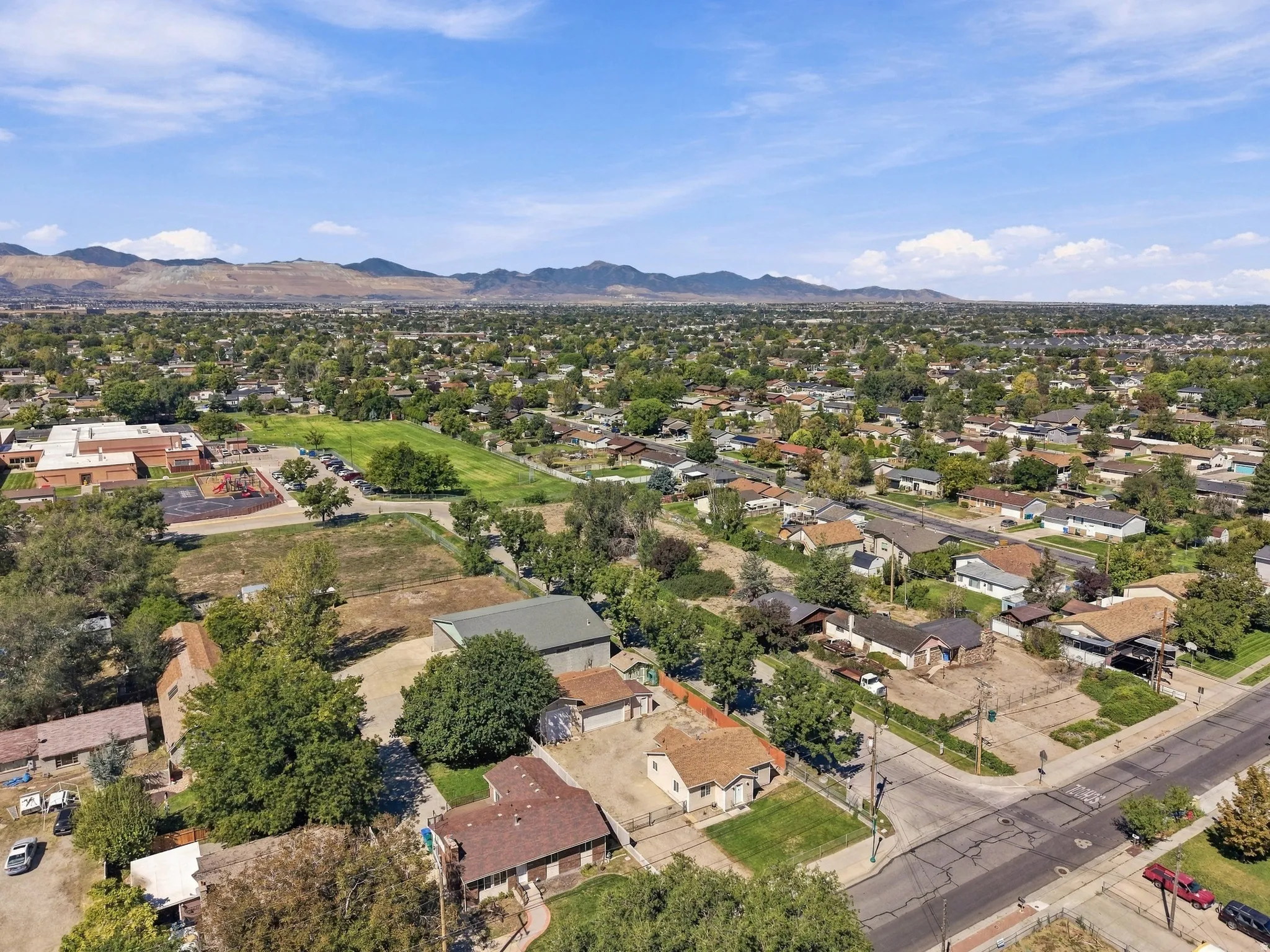 Expansive aerial perspective showcasing a residential neighborhood with distant mountain ranges