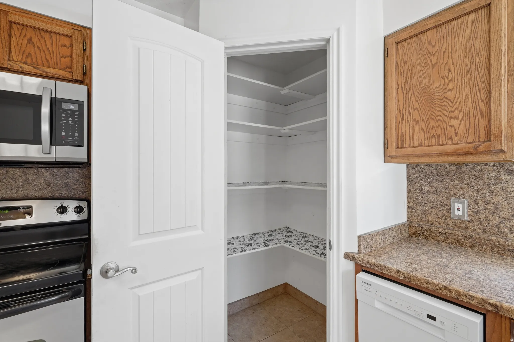 Built-in stainless steel microwave, integrated electric range, and wood-finish cabinetry