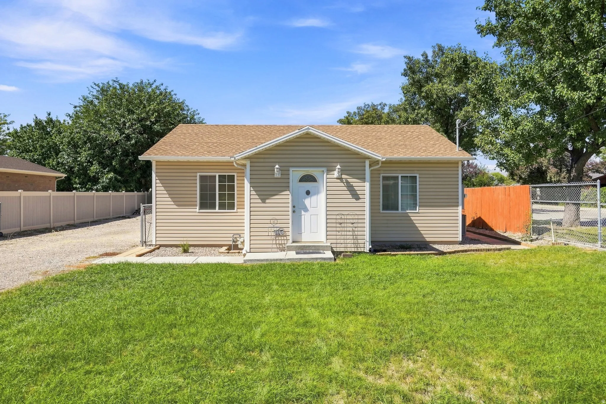Beige horizontal siding exterior with a light brown shingled roof