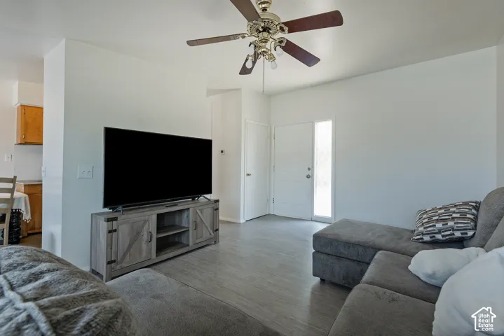 Wood-finish flooring, ceiling fan, and white walls