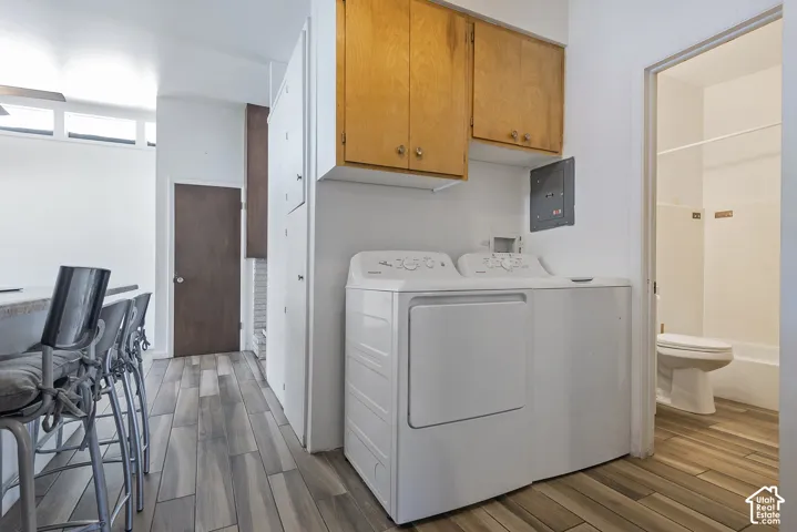 Wood-finish flooring throughout, complemented by a built-in laundry area with overhead cabinetry