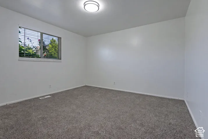 Neutral wall paint with carpeted flooring and a flush-mount ceiling light fixture