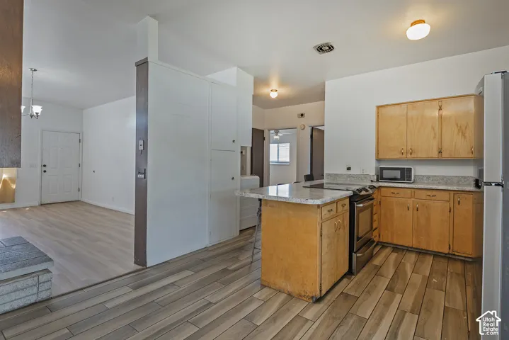 Kitchen with wood cabinetry, granite-style countertops, and stainless steel appliances