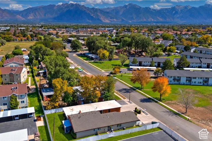 Expansive mountain backdrop with a developed residential area featuring mature trees and paved roadways