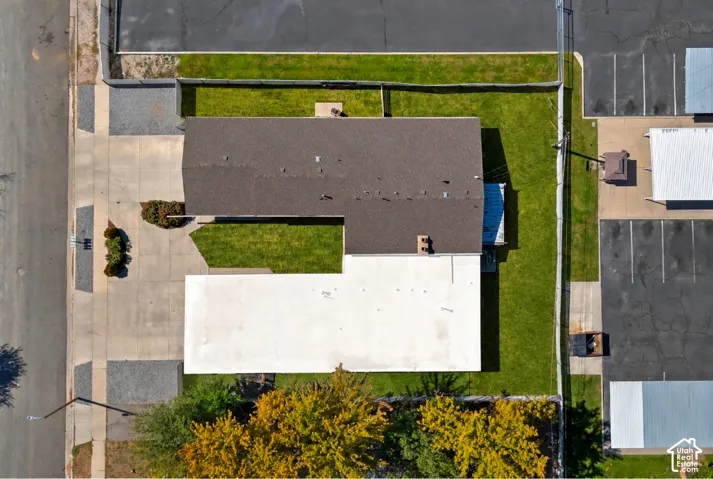 Expansive lot featuring a concrete driveway, established landscaping, and a well-maintained lawn