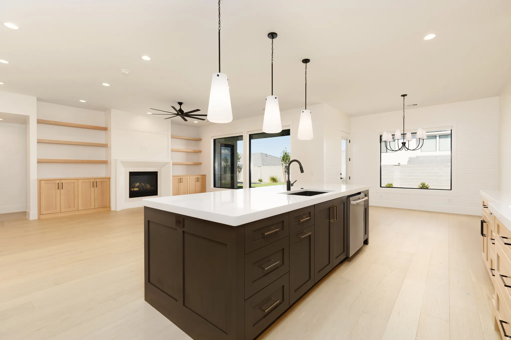 Kitchen island with solid surface countertop, integrated sink, and pendant lighting